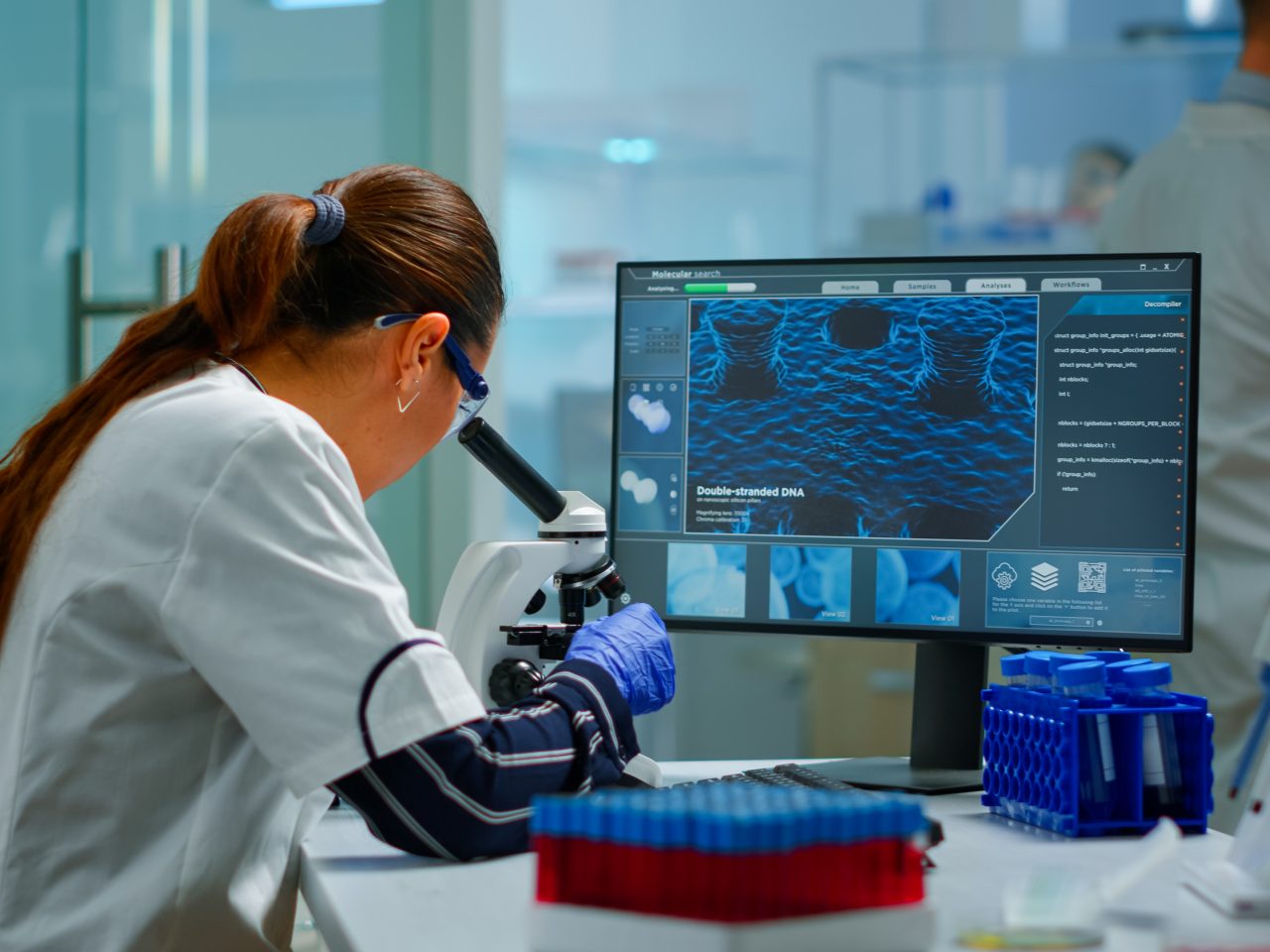 Biotechnology scientist researching in laboratory using microscope