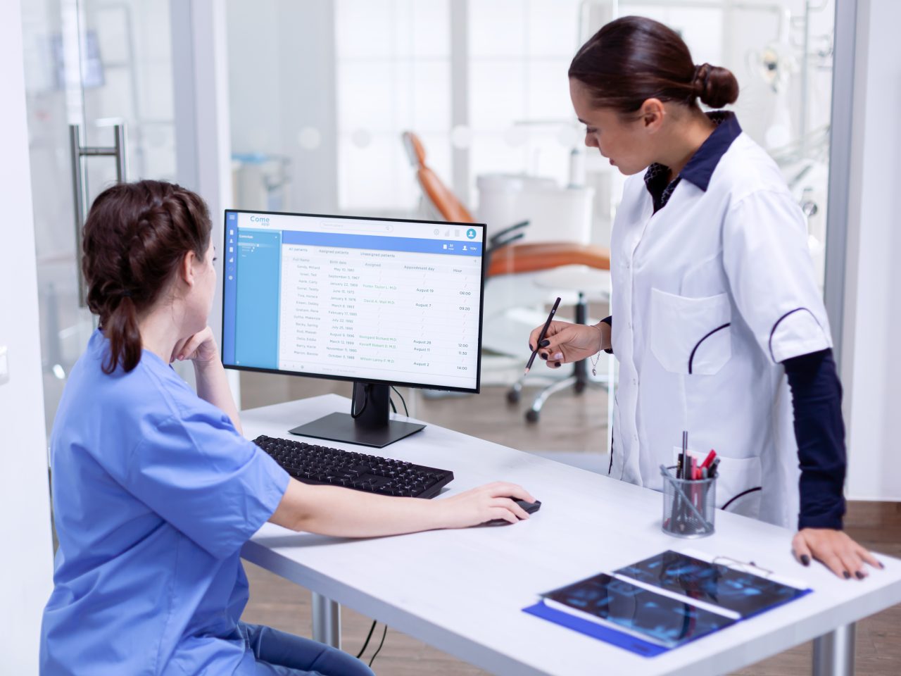 Stomato log and nurse in tooth clinic checking patient appointment.